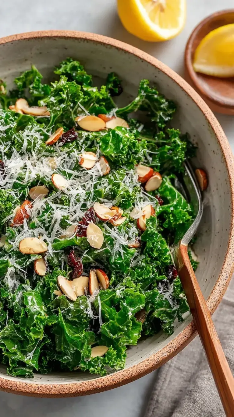A vibrant bowl of massaged kale salad topped with dried cranberries, pumpkin seeds, and shaved parmesan cheese.