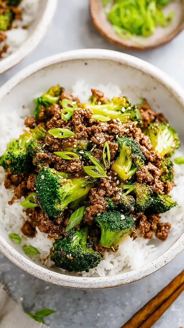 A skillet filled with browned ground beef and vibrant green broccoli in a glossy brown ginger sauce.