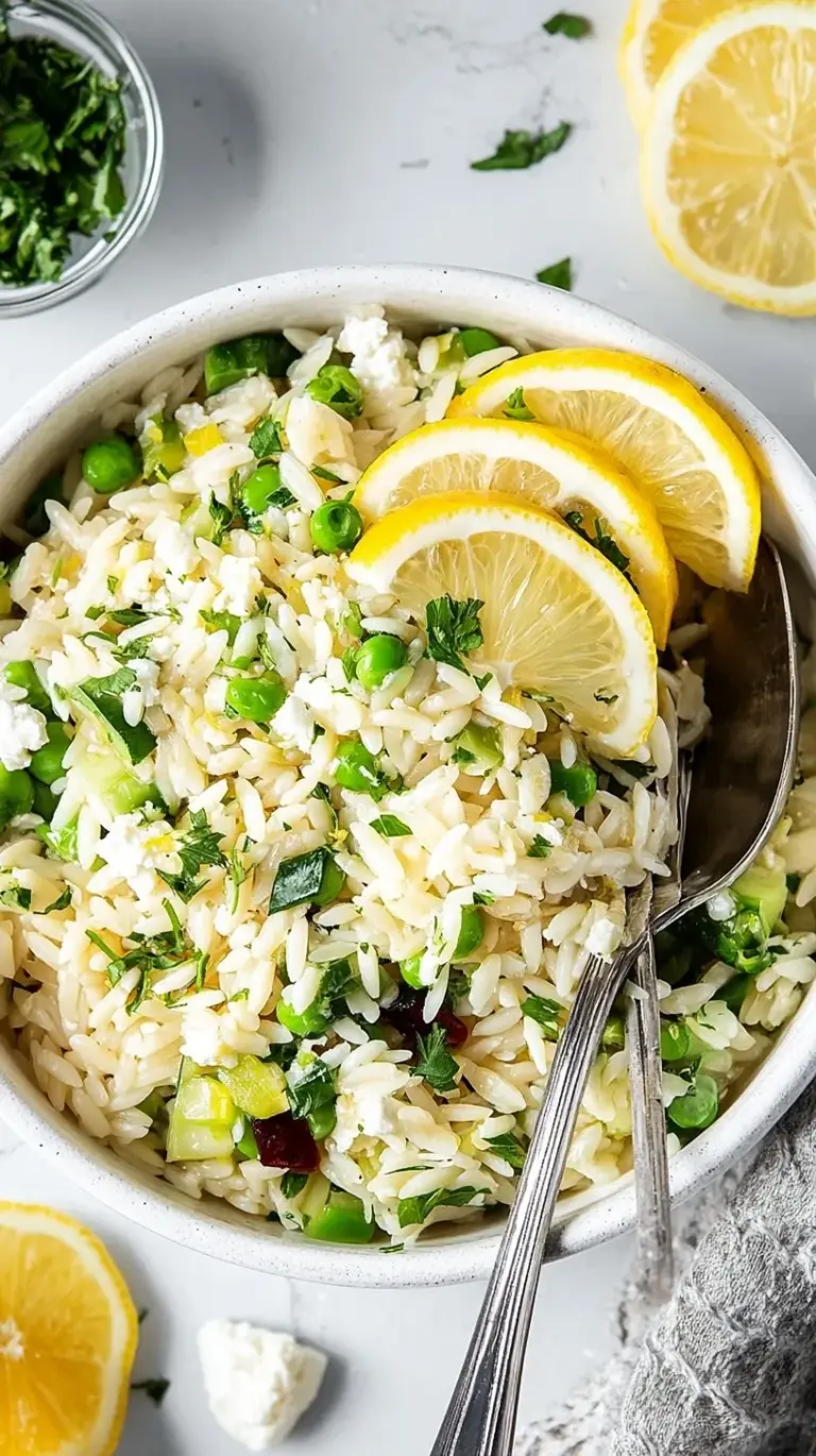 A colorful bowl of lemon orzo salad with cucumbers, tomatoes, and feta cheese