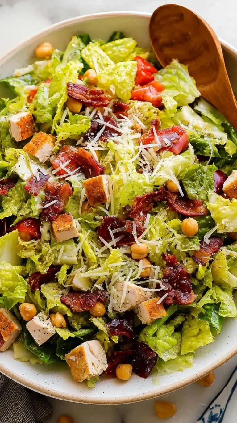 A vibrant bowl of Jennifer Aniston Salad with green herbs, chickpeas, and feta cheese.