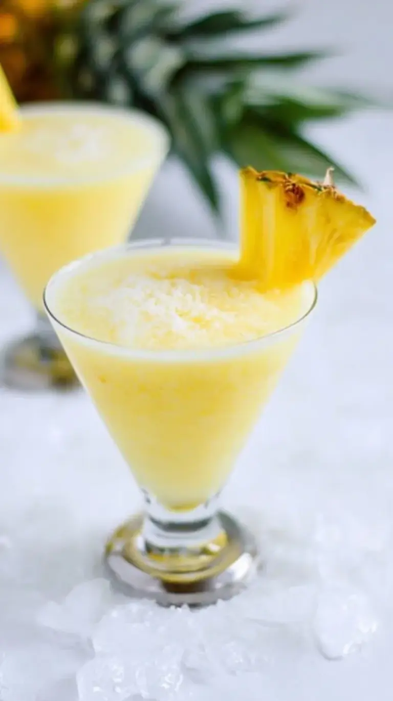 A chilled glass of skinny piña colada with a fresh pineapple wedge garnish