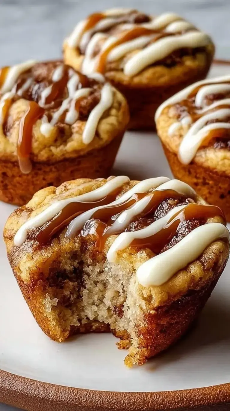 Golden-brown cinnamon roll protein muffins with a visible cinnamon swirl and protein glaze in a muffin tin.