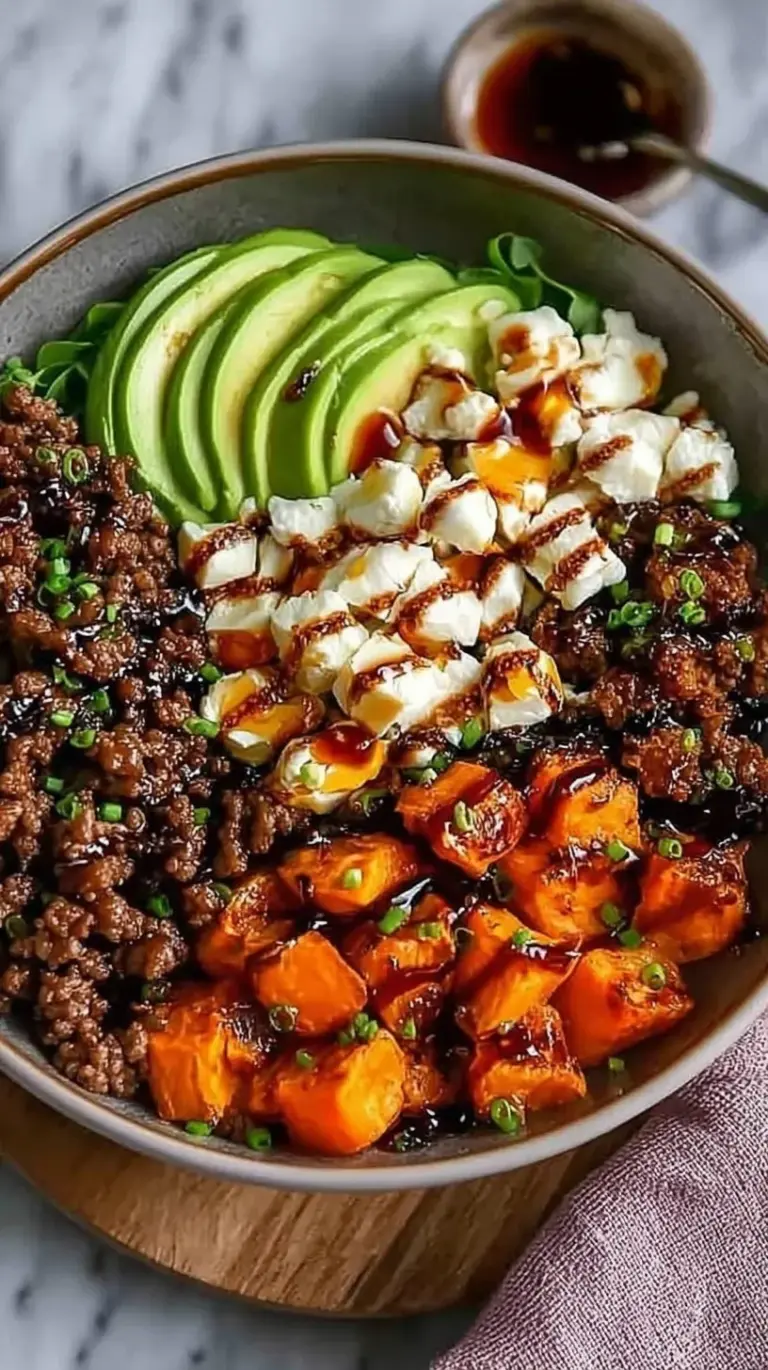 A colorful bowl featuring glazed ground beef, steamed broccoli, and jasmine rice topped with green onions and sesame seeds.