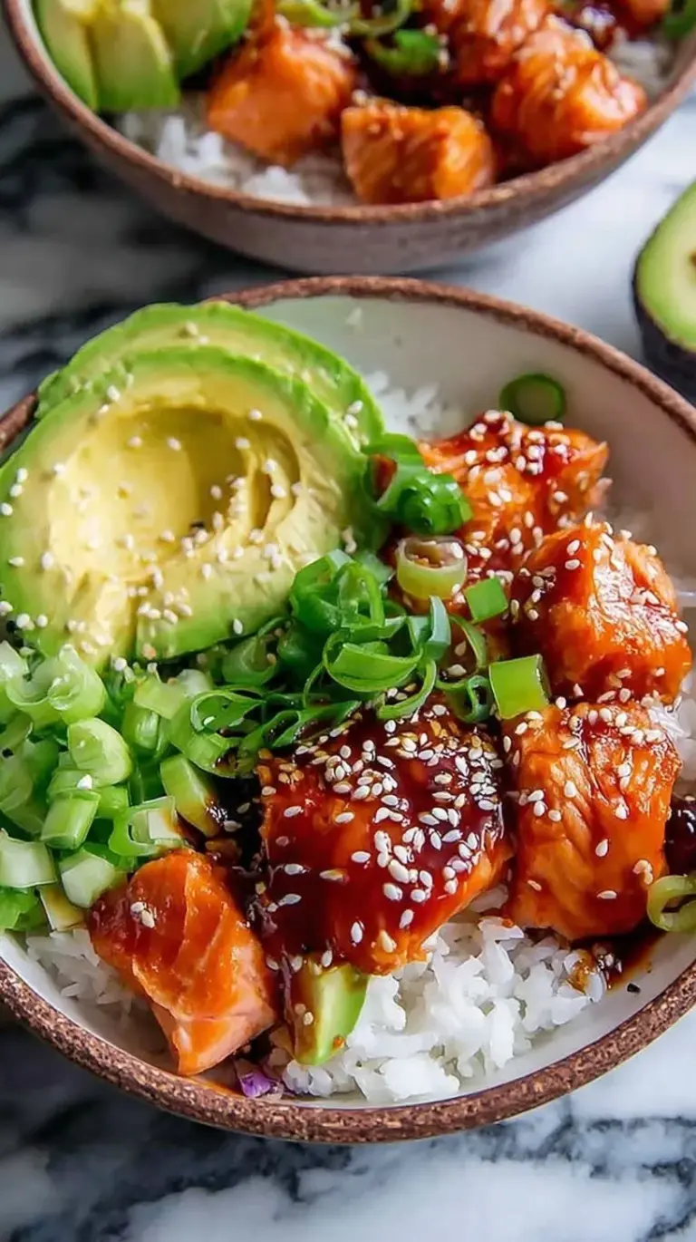 Two bowls of jasmine rice topped with glazed salmon, cucumber slices, and edamame.
