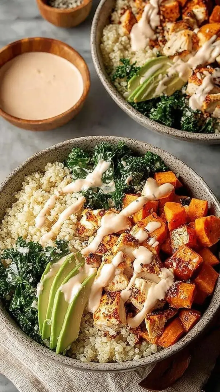 Four glass meal prep containers filled with roasted chicken cubes, orange sweet potatoes, massaged kale, and brown rice.