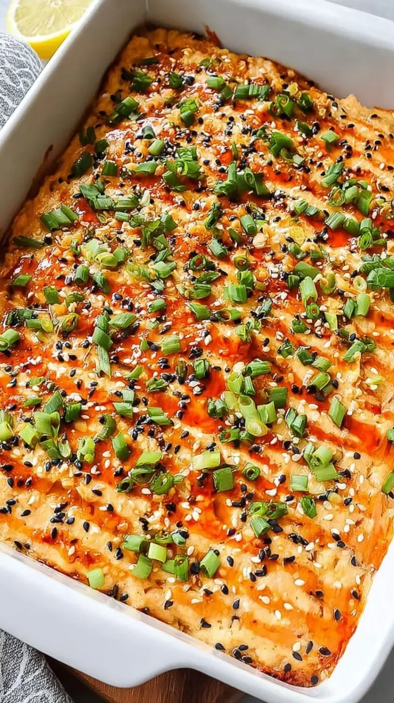 A golden Salmon Sushi Bake in a baking dish topped with green onions and unagi sauce