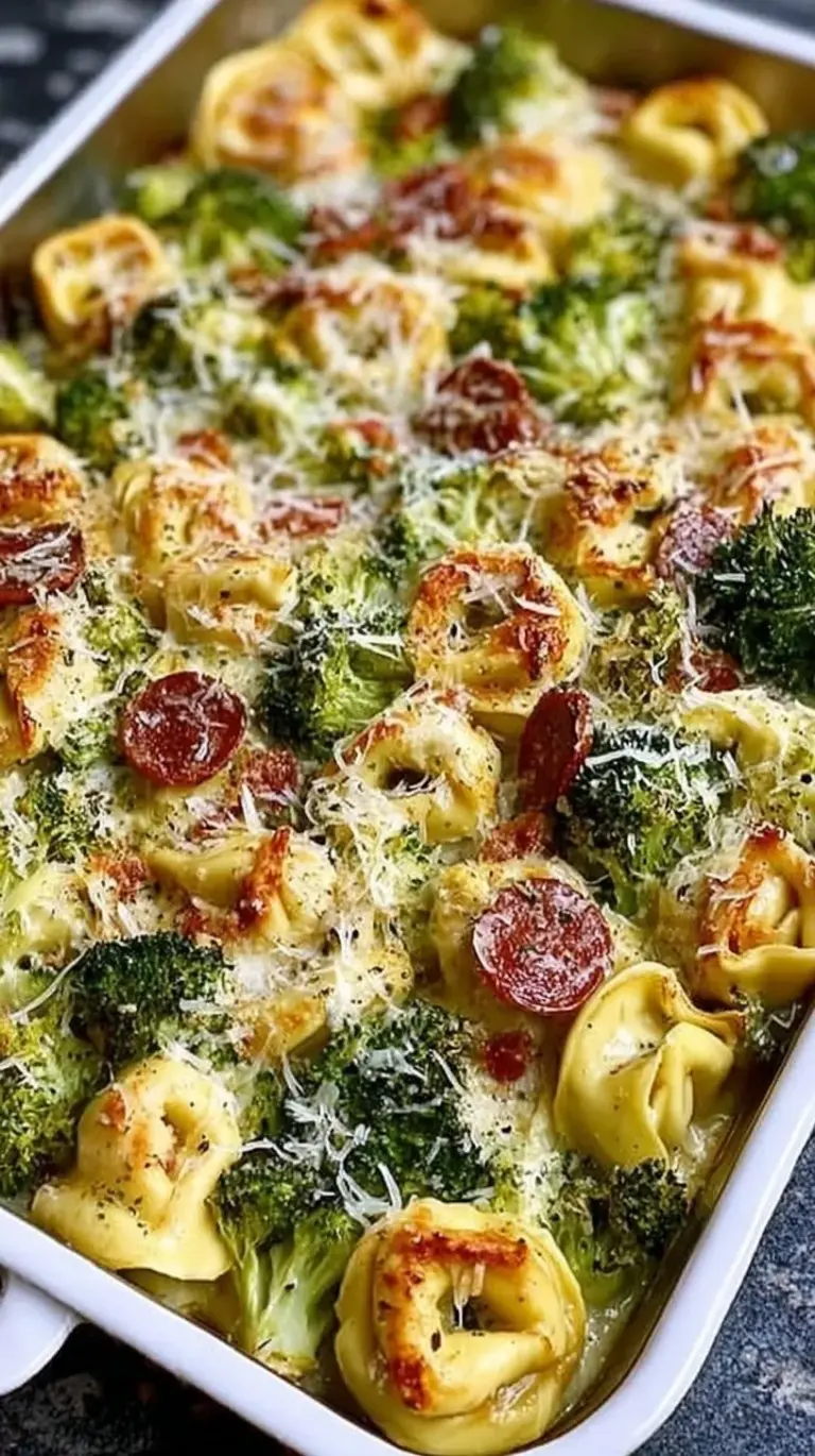 A golden brown sheet pan tortellini bake with melted mozzarella and green broccoli florets.