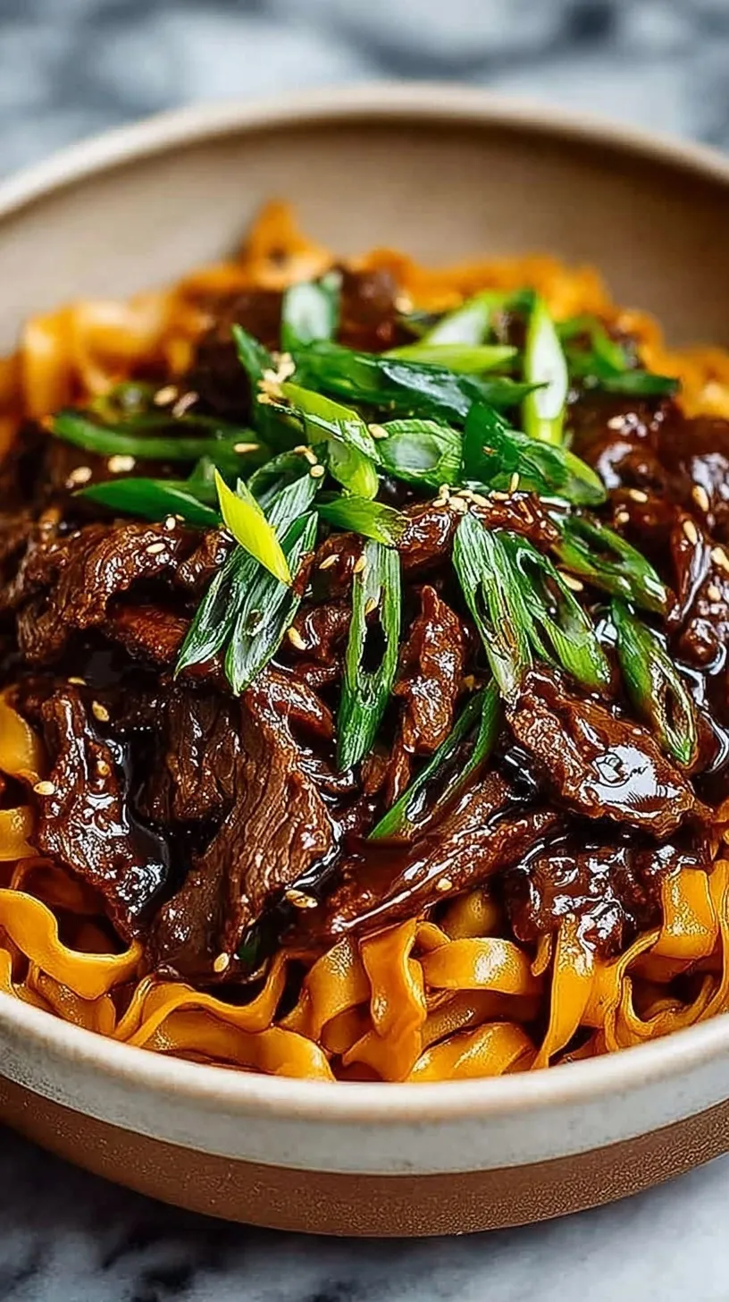 A bowl of slow cooker Korean beef noodles garnished with green onions and sesame seeds
